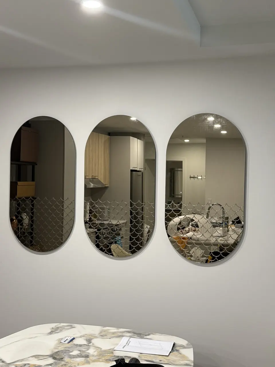 Three oval mirrors aligned on a Montreal condo wall